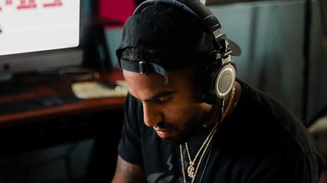 A producer with headphones inside the studio