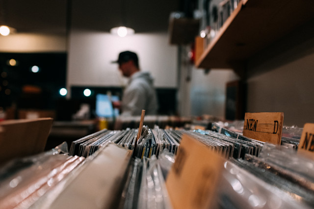 A record store of vinyls with a man in the background