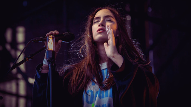 Woman emotionally singing over a mic