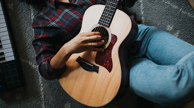 Woman on the floor playing guitar