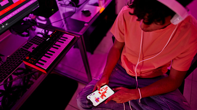 A male producer checking his Soundtrap production on a cell phone