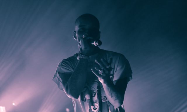 A male rapper on stage holding the microphone