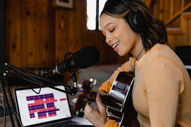 A female guitarist and vocalist recording a song in Soundtrap