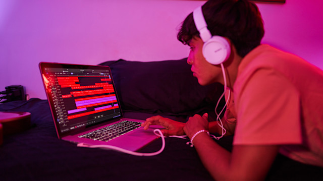 A person in bed making remixes in Soundtrap