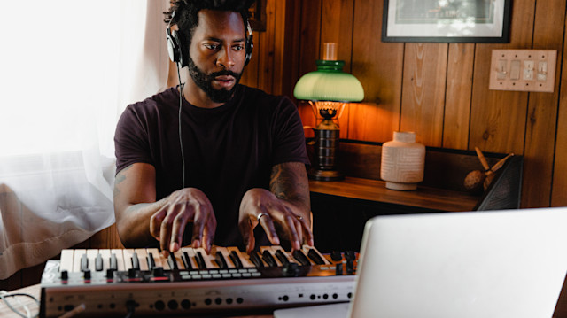 Male songwriter playing a MIDI keyboard